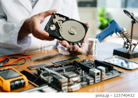 Technician repairing inside of hard disk drive by screwdriver. the concept of data, hardware, technician 123740432