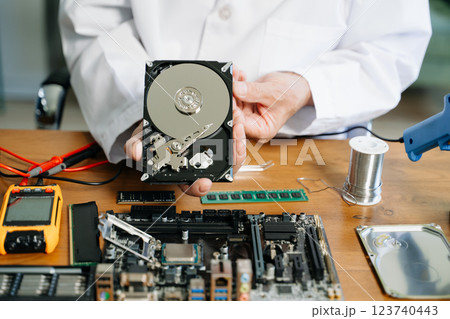 Technician repairing inside of hard disk drive by screwdriver. the concept of data, hardware, technician 123740443