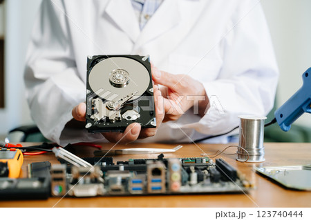 Technician repairing inside of hard disk drive by screwdriver. the concept of data, hardware, technician 123740444