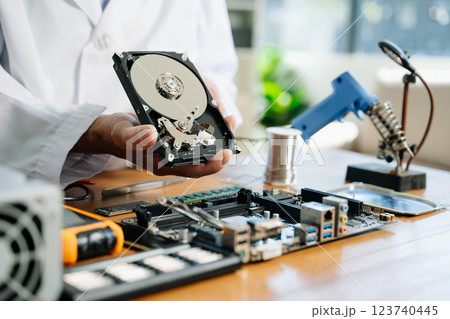 Technician repairing inside of hard disk drive by screwdriver. the concept of data, hardware, technician 123740445
