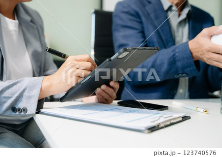 Business partners discussing documents and ideas with smart phone and digital tablet and graph business 123740576