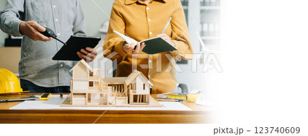 Engineer desk with object paper and tablet with blurry engineer teamwork hardworking Engineer desk with object paper and tablet with blurry engineer teamwork hardworking 123740609
