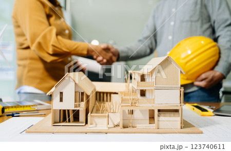 Construction team shake hands greeting start new project plan behind yellow helmet on desk in 123740611