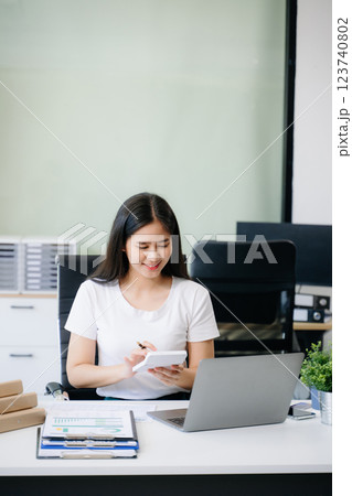 Business woman using tablet and laptop for doing math finance on an office desk, tax, 123740802