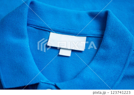 Blank white laundry care clothes label on blue shirt fabric texture background 123741223