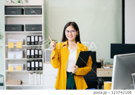 Confident business expert attractive smiling young woman holding digital tablet  on desk 123742106
