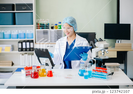 female scientist working with micro pipettes analyzing biochemical 123742107