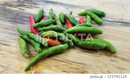 Fresh Green and Red Chili Peppers on Wooden Cutting Board 123742124