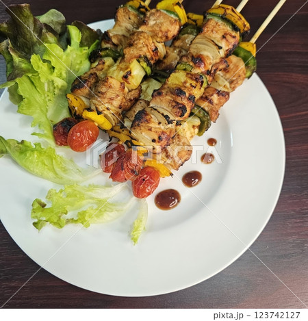 Grilled Vegetable and Meat Skewers Served on White Plate 123742127