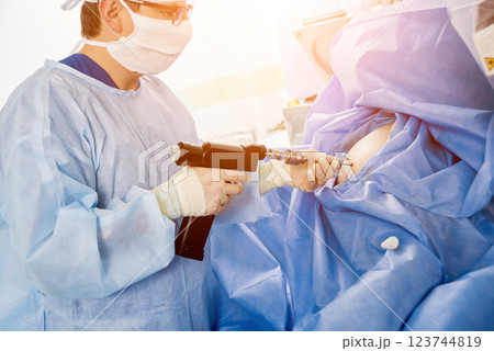 Arthroscope surgery. Orthopedic surgeons in teamwork in the operating room Arthroscope surgery. Orthopedic surgeons in teamwork in the operating room 123744819