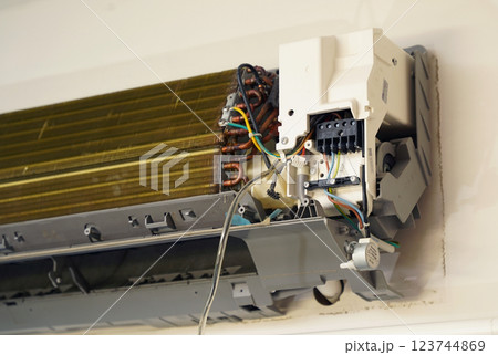 The worker cleans and repairs the air conditioner to ensure it operates properly 123744869