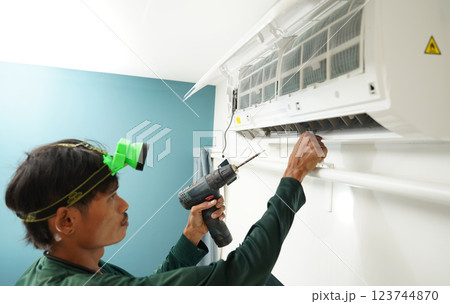 The worker cleans and repairs the air conditioner to ensure it operates properly 123744870