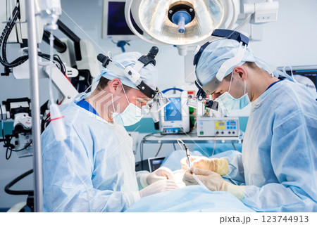 Spinal surgery. Group of surgeons in operating room with surgery equipment.  123744913