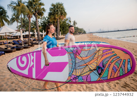 Two young surfers going into the sea with surf boards Two young surfers going into the sea with surf boards 123744932