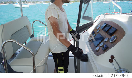 Young male captain in black gloves steering voyage boat 123744968
