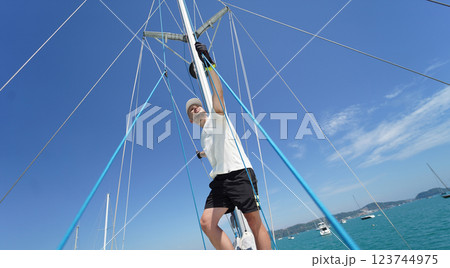 Male captain stands proudly on a sailboat enjoying the moment 123744975