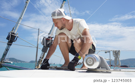 A man in a white hat is working on a voyage boat A man in a white hat is working on a voyage boat 123745003