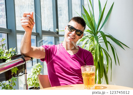 Young man in the pub. Drinking beer, eating pizza. 123745012