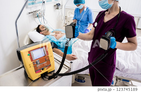 Doctors give resuscitation to a male patient in the emergency room. 123745189