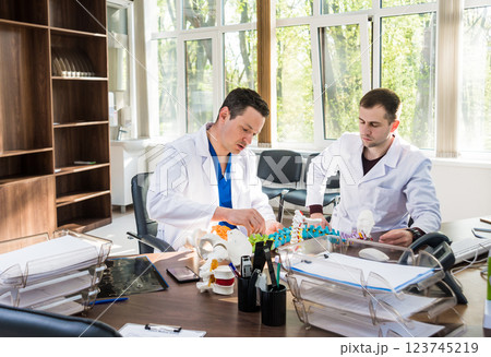 Doctor show polyaxial screw on the spine model. Spine fixation systems Doctor show polyaxial screw on the spine model. Spine fixation systems 123745219