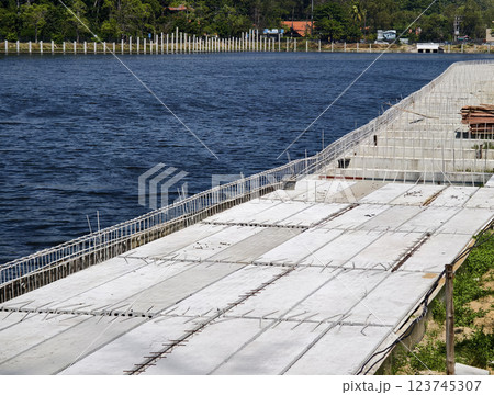 Construction of a modern pedestrian embankment on a large lake Construction of a modern pedestrian embankment on a large lake 123745307