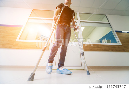 Injured man trying to walk on crutches in the hospital. 123745747