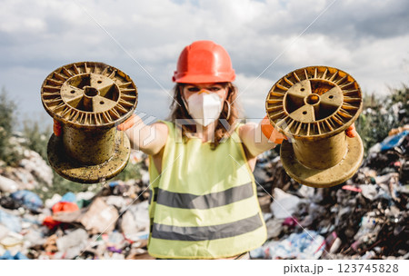 Woman volunteer helps clean the field of nuclear waste and plastic garbage. Woman volunteer helps clean the field of nuclear waste and plastic garbage. 123745828