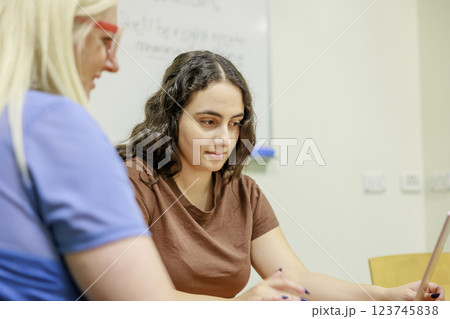 オフィスで働く若い女の子と同僚 オフィスで働く若い女の子と同僚 123745838