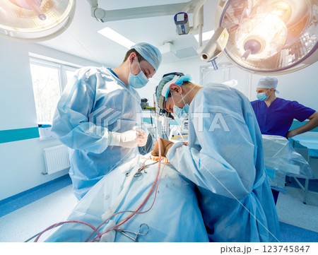 Spinal surgery. Group of surgeons in operating room with surgery equipment.  123745847