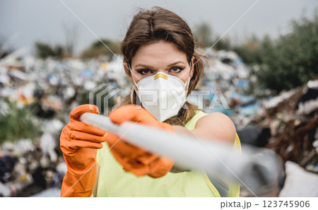 Woman volunteer helps clean the field of plastic garbage. Woman volunteer helps clean the field of plastic garbage. 123745906