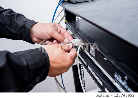 Technician connecting network cables to switches. Connecting cables  123745952