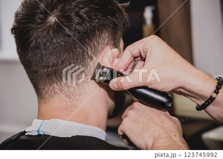 Young man with trendy haircut at barber shop.  123745992