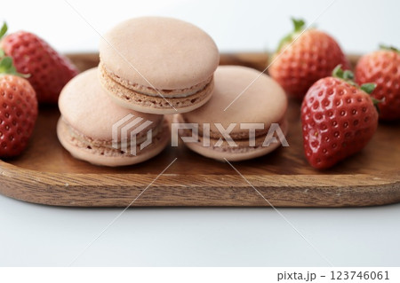 木のお皿にのせたストロベリーマカロンとヘタ付のイチゴ 123746061