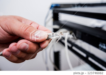 Technician connecting network cables to switches. Connecting cables  123746082