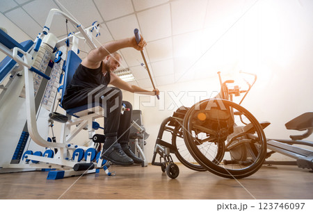 Disabled man doing strength exercises separate from the wheelchair. 123746097