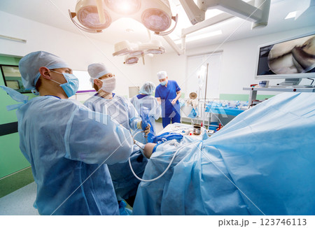 Arthroscope surgery. Orthopedic surgeons in teamwork in the operating room Arthroscope surgery. Orthopedic surgeons in teamwork in the operating room 123746113