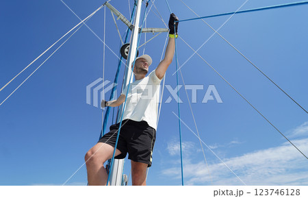 Male captain stands proudly on a sailboat enjoying the moment 123746128