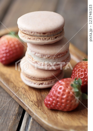 木のお皿にのせたストロベリーマカロンとヘタ付のイチゴ 123746183