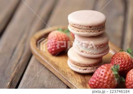 木のお皿にのせたストロベリーマカロンとヘタ付のイチゴ 木のお皿にのせたストロベリーマカロンとヘタ付のイチゴ 123746184