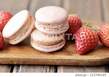 木のお皿にのせたストロベリーマカロンとヘタ付のイチゴ 123746185