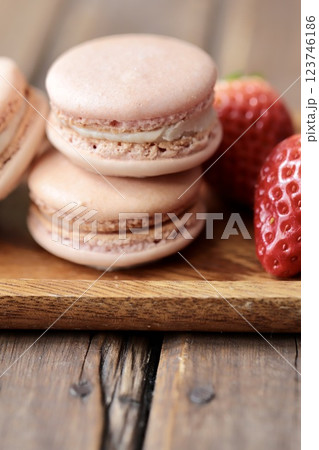 木のお皿にのせたストロベリーマカロンとヘタ付のイチゴ 123746186