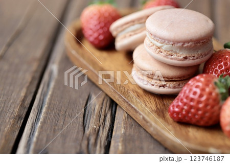 木のお皿にのせたストロベリーマカロンとヘタ付のイチゴ 123746187