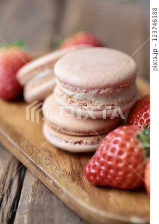木のお皿にのせたストロベリーマカロンとヘタ付のイチゴ 123746188