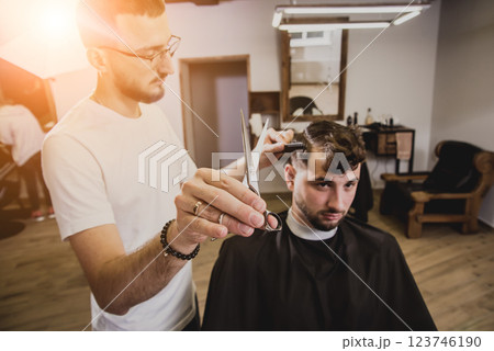 Young man with trendy haircut at barber shop.  123746190