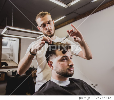 Young man with trendy haircut at barber shop. Young man with trendy haircut at barber shop. 123746242