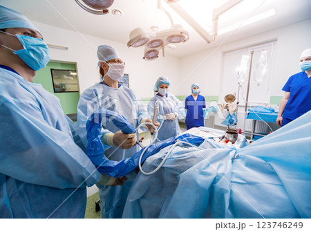 Arthroscope surgery. Orthopedic surgeons in teamwork in the operating room  123746249