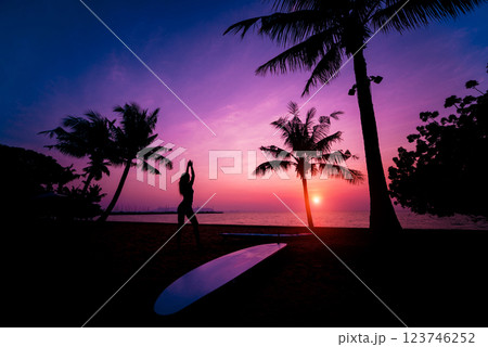 Silhouette of surfer girl with long surf board at sunset on tropical beach Silhouette of surfer girl with long surf board at sunset on tropical beach 123746252
