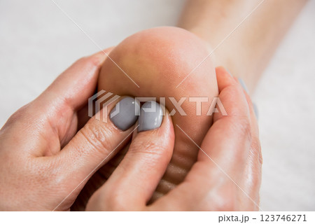 Beautiful young woman enjoying foot massage in spa salon. Cosmetology Beautiful young woman enjoying foot massage in spa salon. Cosmetology 123746271