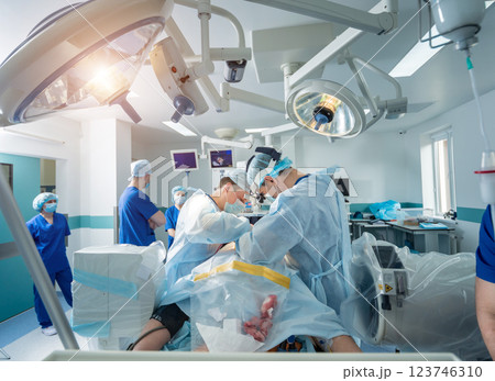 Spinal surgery. Group of surgeons in operating room with surgery equipment.  123746310