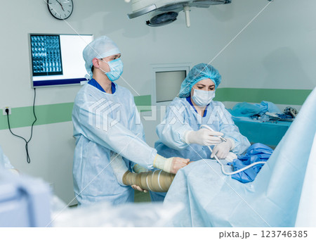 Arthroscope surgery. Orthopedic surgeons in teamwork in the operating room Arthroscope surgery. Orthopedic surgeons in teamwork in the operating room 123746385